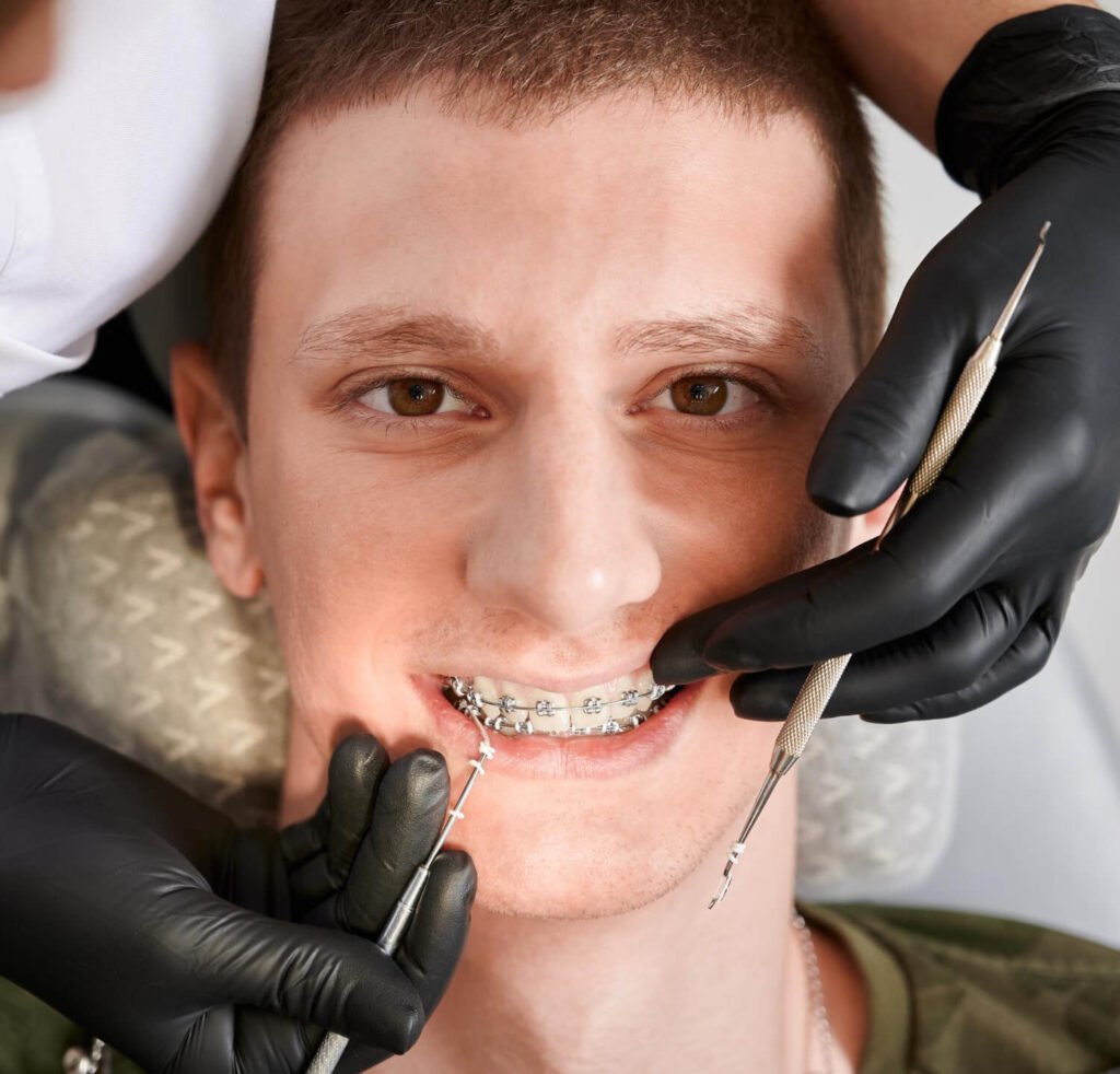 Dentista ajustando aparelho ortodôntico em paciente jovem em Brasília como preparo antes da cirurgia ortognática com a Dra Viviane.